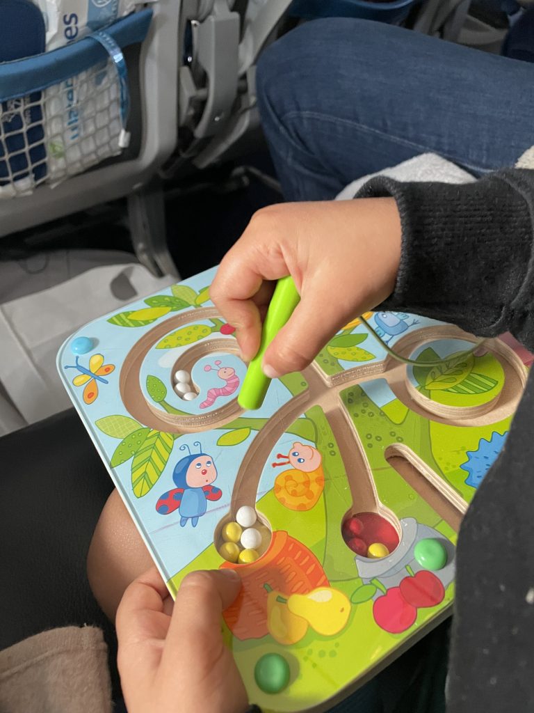 Kleinkind mit Beschäftigung für den Handgepäck Kleinkind Flug